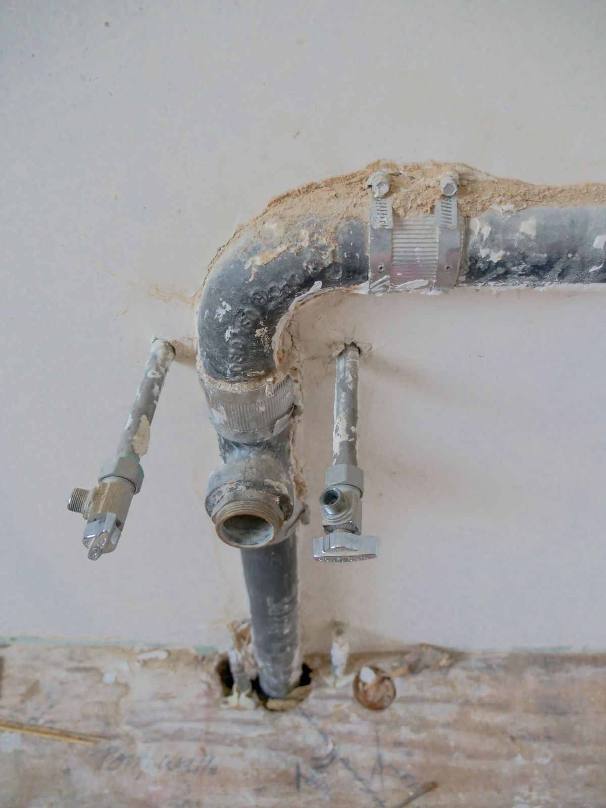 Plumbing rough-in pipes in a wall under renovation