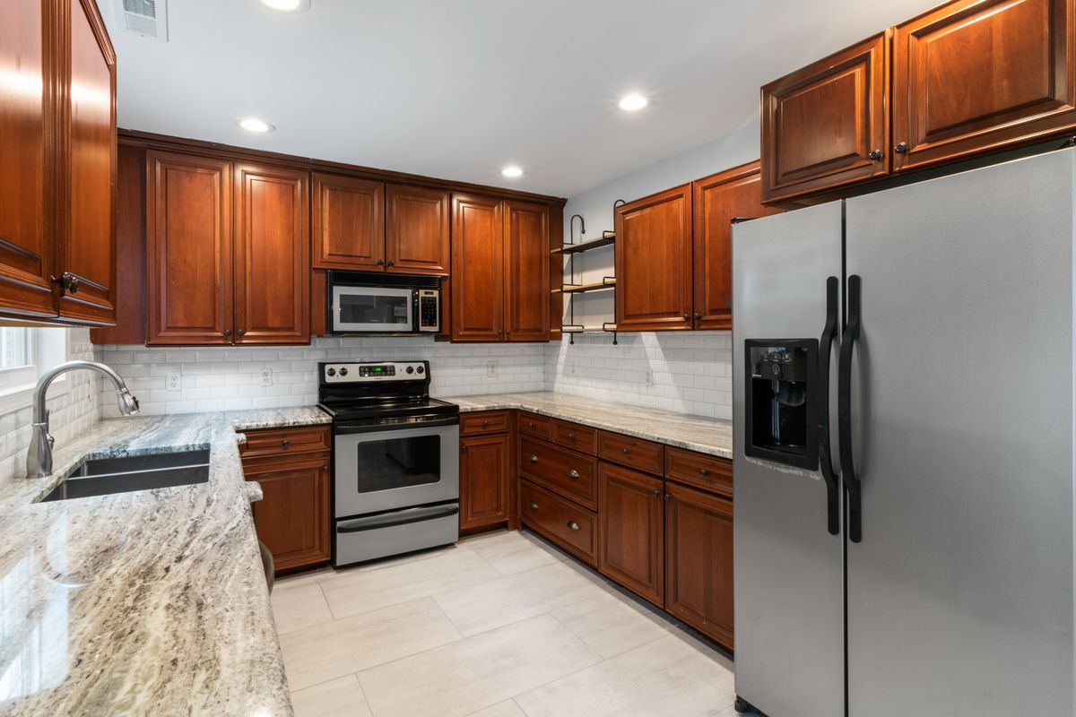 Renovated kitchen with new cabinets and stone countertops