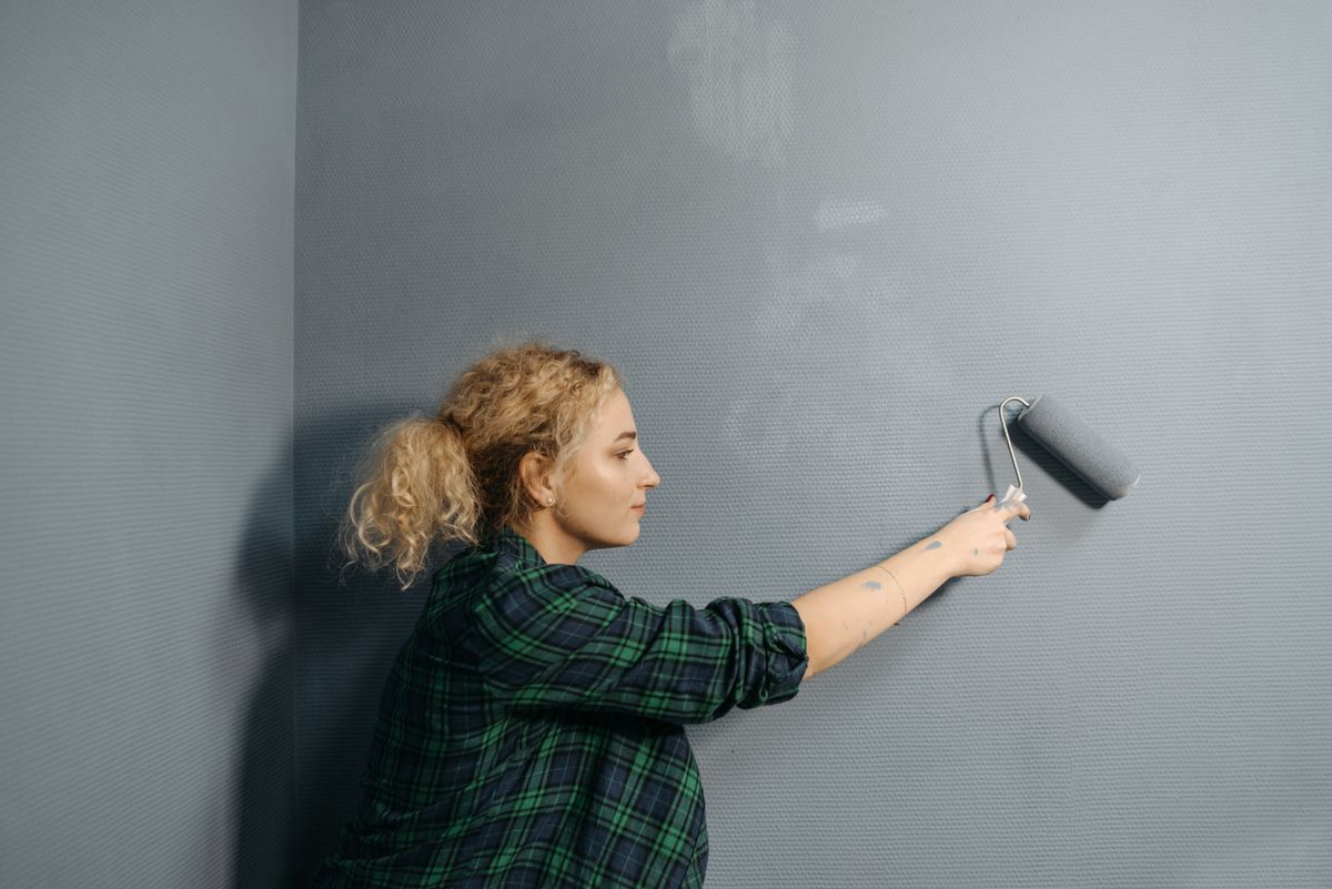 Painter rolling fresh paint onto an interior wall