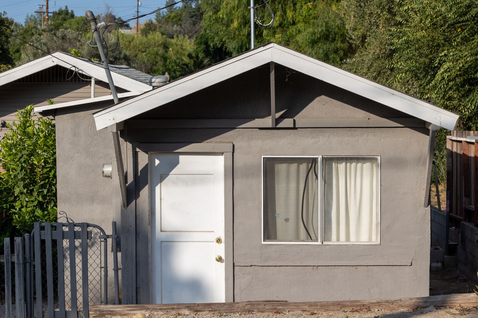 Small gray detached accessory dwelling unit with a pitched roof